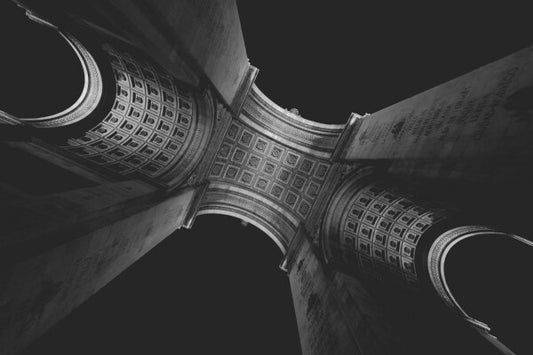 Adorn your walls with the timeless elegance of the Arc de Triomphe with our stunning canvas print. This black and white image, captured from below, offers a unique perspective of the iconic monument and will add a touch of Parisian charm to any room in your home. Allow yourself to be transported to the heart of the City of Light with this captivating piece of art.