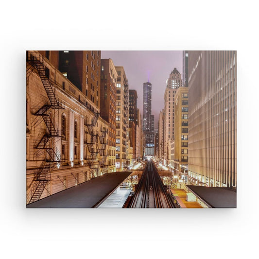 Our canvas print of a photograph capturing the elevated train tracks looking north down Wabash Avenue in Chicago is a stunning addition to any space. The black and white image captures the bustling energy of the city, with the train tracks leading the eye towards the iconic Chicago skyline in the distance. Bring a touch of urban energy to your home or office with this captivating piece of art.